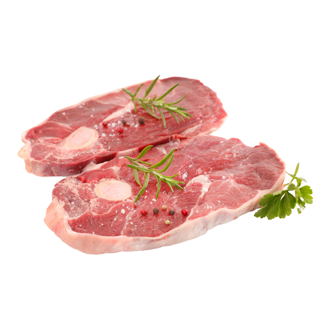 Two raw bone-in lamb leg chops with a sprig of rosemary and a leaf of parsley on a white background.